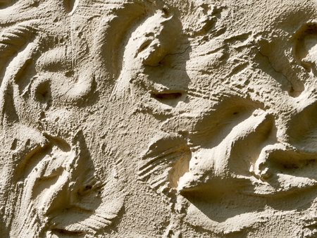Texture of a clay wall of ocher color illuminated by the sun in a natural environment