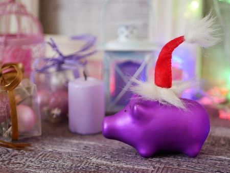 Christmas toy piglets in Santa's red hats, festive illumination, candlesの写真素材
