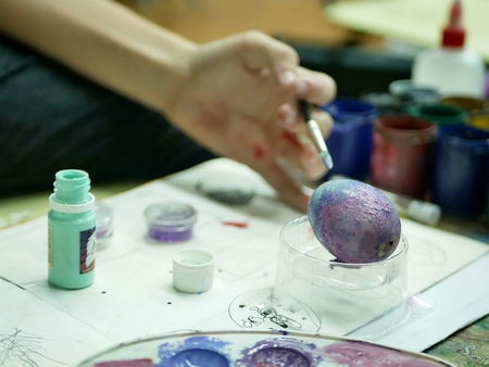 hands of the student painted eggs for easterの写真素材