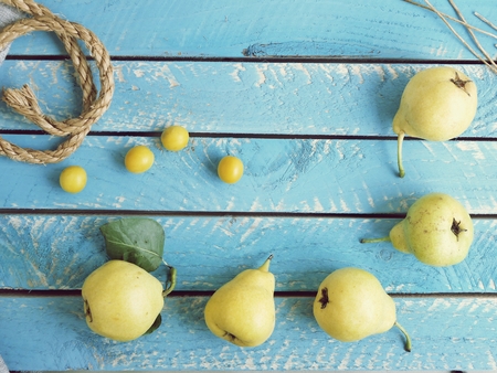 Yellow ripe pears on a blue wooden tableの写真素材