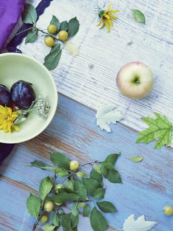Fruits, flowers, leaves on a wooden backgroundの写真素材