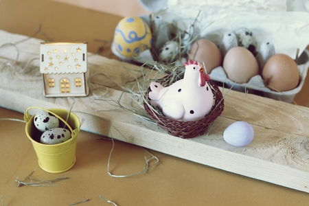 Eggs, toy chicken, easter decor on a light wooden table