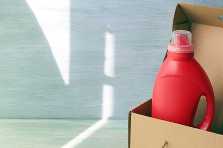 Liquid detergents in plastic bottles, rubber gloves for cleaning the house on a wooden table, home deliveryの写真素材