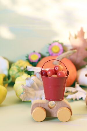 Pumpkins, toy car and autumn leaves on a yellow background, concept of harvesting, fertility, Thanksgivingの写真素材