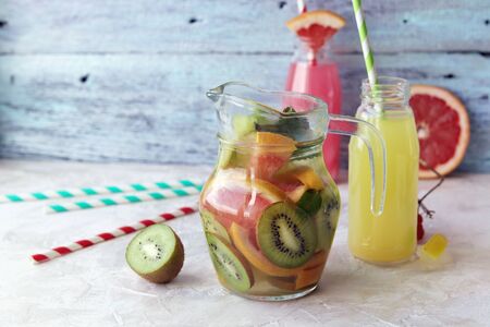 Refreshing drink, natural cocktail of organic fruits and berries in glass bottles on the windowsill, healthy food, home cookingの写真素材