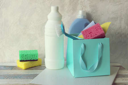 Liquid detergents in plastic bottles, sponges and brushes, rubber gloves for house cleaning and...