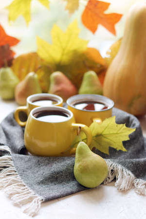 Three cups of coffee, pumpkins, leaves, woolen scarf, the concept of home comfort, family, Thanksgiving, autumn seasonの写真素材