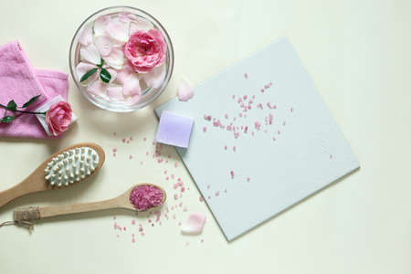 Fresh pink roses, water, petals, candles on a light background, body care products, natural home...