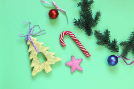 Christmas background, a wreath of fir branches with New Year's decorations on bright green paper,...