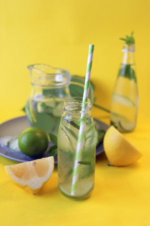 Healthy cold drink of citrus, tarragon, cucumber and mint leaves, on a bright background, summer,...