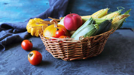 Fresh ripe variety of vegetables in a basket, on a concrete table, organic natural products, healthy food, home cookingの写真素材