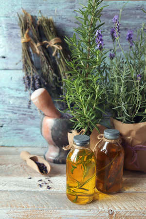 Lavender and rosemary fresh, blooming in a pot, tinctures and aromatic oil, bunches of dried flowers on a wooden background, useful plants, alternative medicineの写真素材