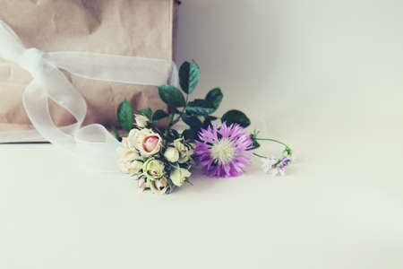 Bouquet of fresh roses, a package with flowers on a light background with a place for an inscription, the concept of a romantic congratulation, invitation, wedding, postcard, Valentines, shopの写真素材