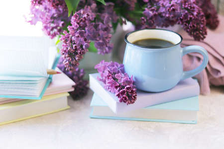 Books, notepads and fresh lilac flowers on the table by the window, the concept of education, home reading, learning, back to school, spring, vacationの写真素材