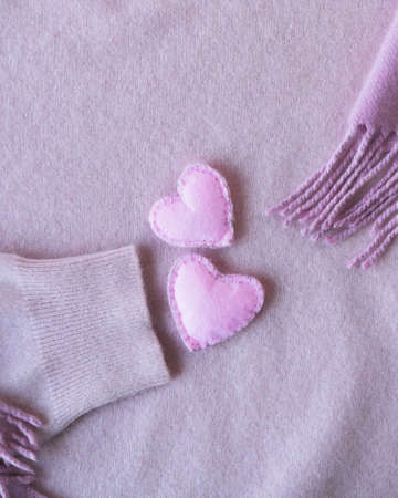 Woolen cute hearts decorate pink cashmere clothes, top view, Valentine's day concept, warm cozy...