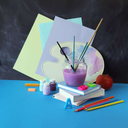 Drawing learning supplies on table, stack of books on chalkboard background, back to schoolの写真素材