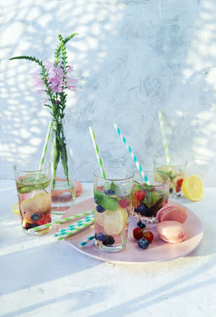 Refreshing detox drinks from organic fruits, berries, citruses and mint leaves in glasses, a bouquet...