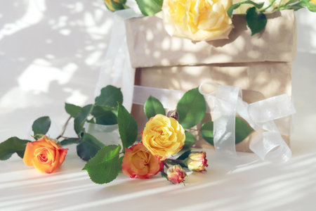 Gift box with yellow roses on white background. flat lay.の写真素材