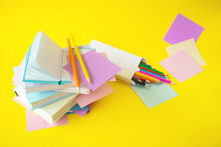 colorful sticky notes and pencils on yellow background with copy spaceの写真素材
