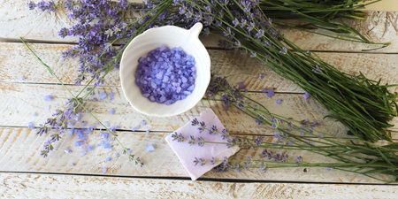 Lavender bath salt and fresh lavender flowers on wooden backgroundの写真素材