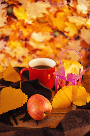 Autumn still life with cup of coffee, apple and autumn leaves.の写真素材