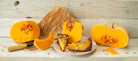 Slices of pumpkin pie with pumpkin seeds on a wooden backgroundの写真素材