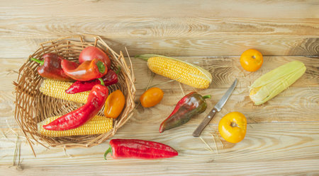 Vegetables in a basket on a wooden background, top view