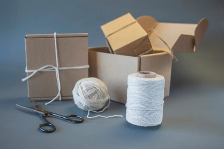 Boxes, scissors and twine on a gray background. Craft package.