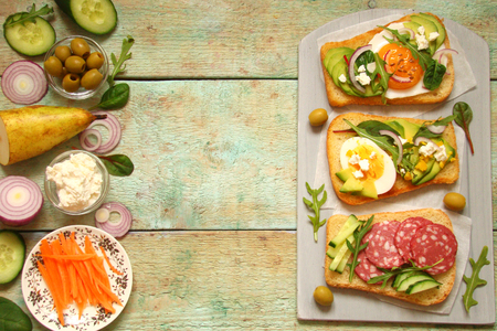 vegetarian sandwich with avocado, cream cheese, cucumber, herbs, carrot, onion, tomatoの写真素材