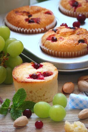 Muffins with cranberries, fruit and milk for Breakfast on a light backgroundの写真素材