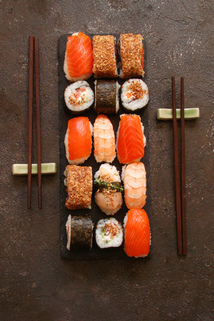 sushi and sushi rolls, sushi nigiri on stone plate on dark backgroundの写真素材