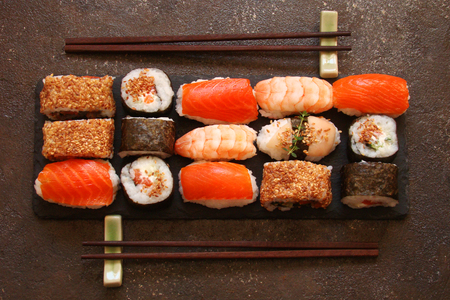 sushi and sushi rolls, sushi nigiri on stone plate on dark backgroundの写真素材