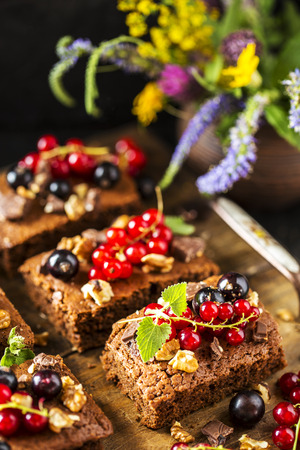 brownie chocolate cake with fresh berries, currants, and mint and nutsの写真素材