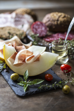 Italian prosciutto with melon, food, olives, sausage, ham and herbs, Basilの写真素材
