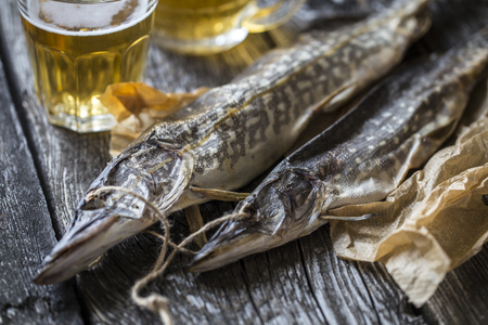 fish pike: dried, dried with a glass of beer on wooden boardsの写真素材