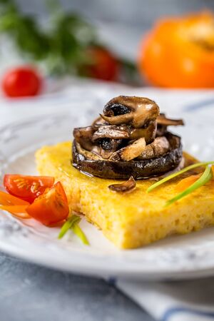 corn polenta with roasted mushrooms and eggplant, traditional Italian food with vegetables and thymeの写真素材