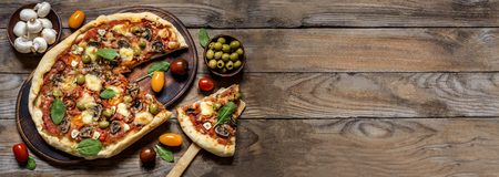 banner for advertisement pizza with mushrooms, tomatoes, olives and spinach on wooden backgroundの写真素材