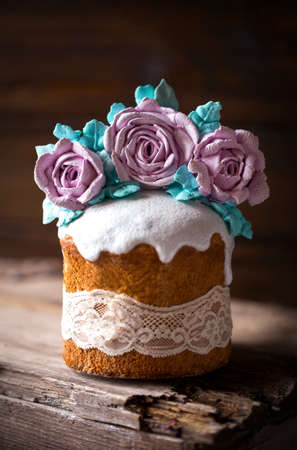easter cake decorated with roses meringue flowers on a dark background