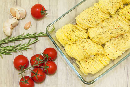 Thinly sliced ??potato slices with spices in glass formの写真素材