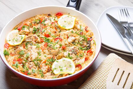 Paella with chicken, tomatoes and pepper . Traditional Spanish dish. Selective focusの写真素材