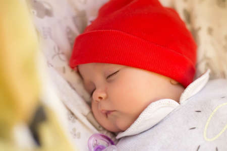 Newborn baby is sleeping in a stroller. Close-up. Selective focus.の写真素材
