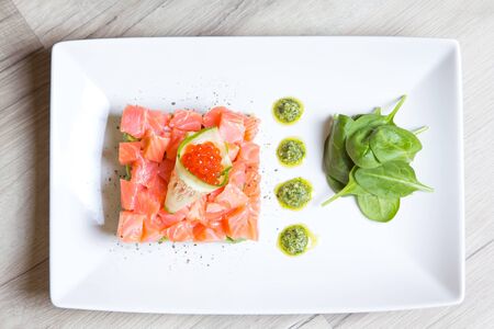 Tartare from salmon, caviar and avocado with pesto sauce and spinach. Close-up, selective focus.の写真素材
