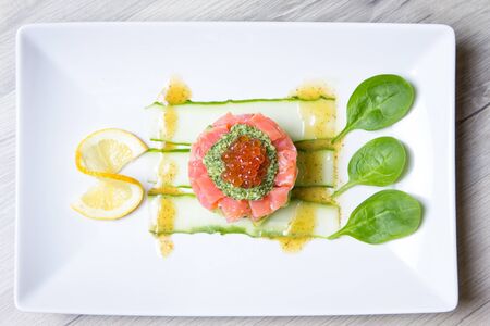 Tartare from salmon, caviar and avocado with pesto sauce and spinach. Close-up, selective focus.の写真素材