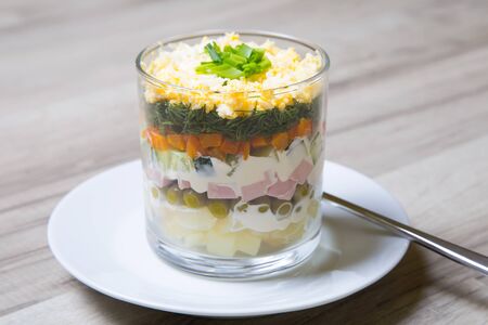 Traditional Russian salad Olivier with sausage in a glass. Selective focus, close - up.の写真素材