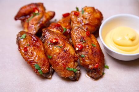 BBQ chicken wings with sauce on paper. Close-up, selective focus.の写真素材