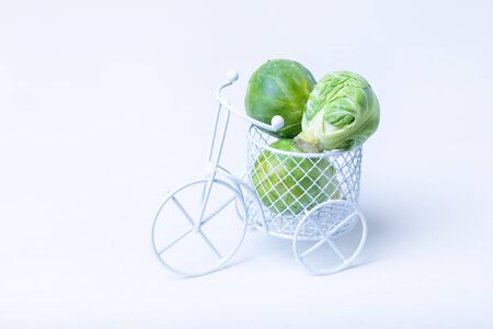 Brussels sprouts in a miniature bike. White background, isolate. Close-up, selective focus.の写真素材