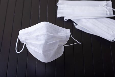 Medical white masks on a black background. Surgical protective mask against viruses and bacteria....
