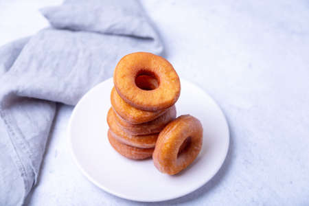 Donuts. Traditional donuts in the shape of a ring fried in oil. Unhealthy but tasty food. Close-up, light background.の写真素材