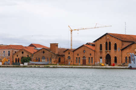 Industrial shipyards (Arsenale di Venezia) in Italy, Venice. Loading cranes and docks. Cloudy, summer.の写真素材