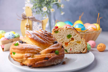 Cutaway Craffin (Cruffin) with raisins and candied fruits. Traditional Easter Bread Kulich and painted eggs on a gray background. Easter Holiday. Close-up, selective focus.の写真素材